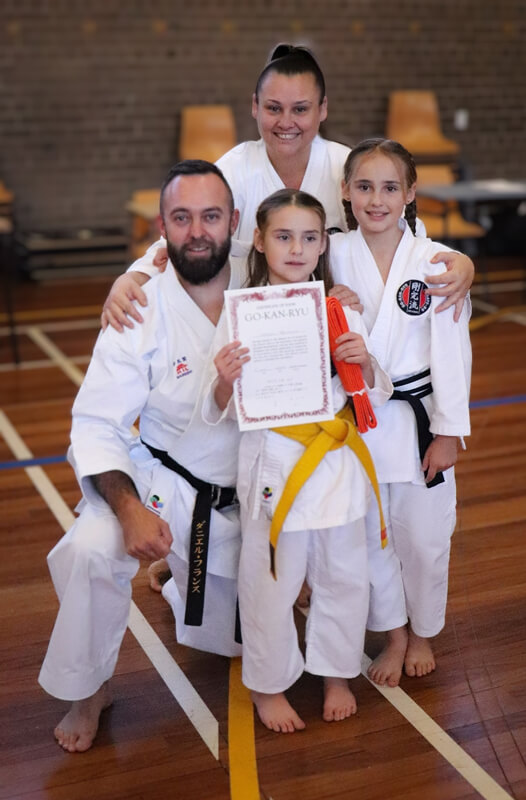 Family karate training - a mother and father with their two daughters after a karate grading. Family karate training - a mother and father with their two daughters after a karate grading.