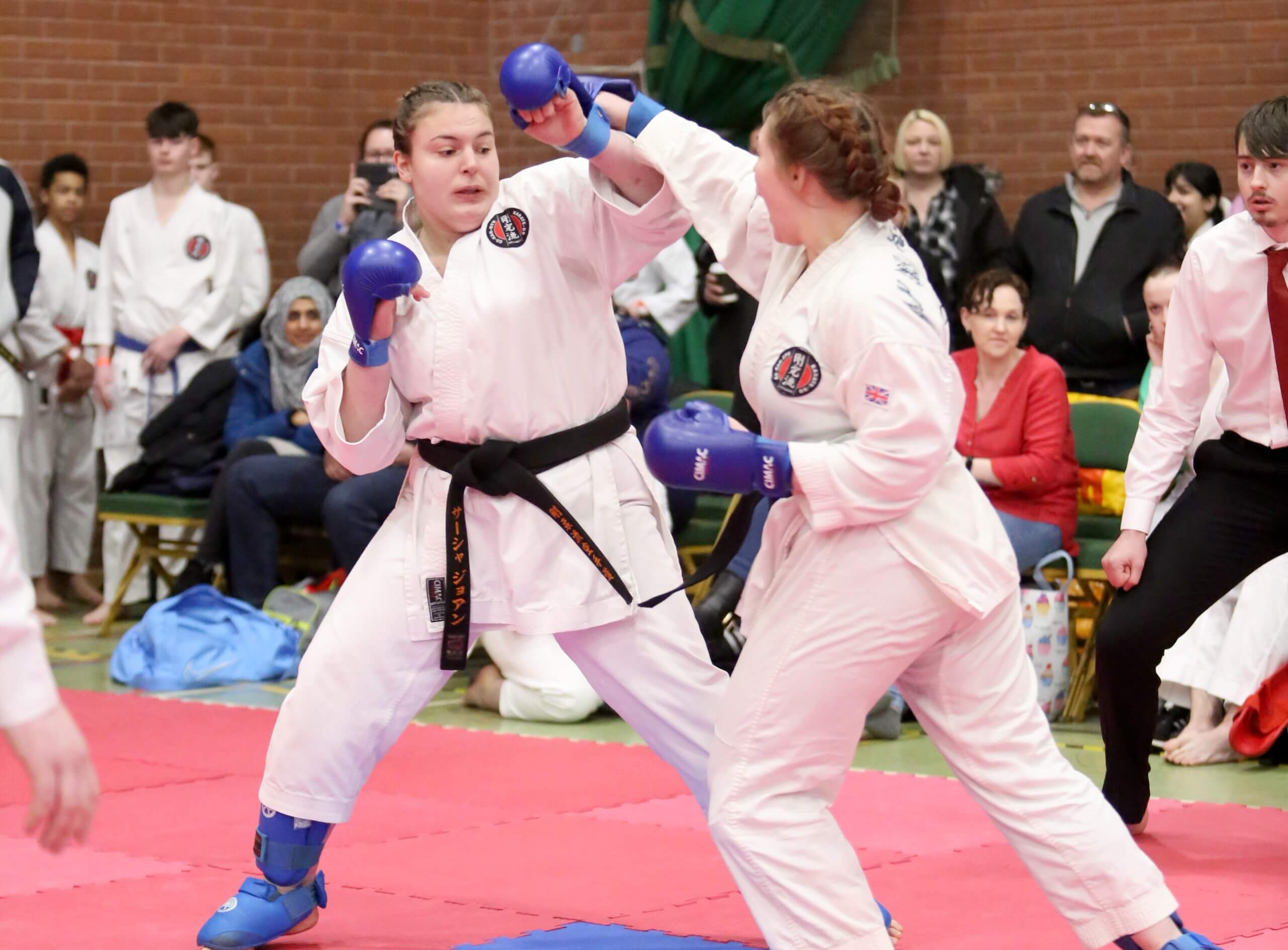 strength two students compete against each other in karate, both are wearing black belts